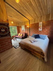 une chambre avec un grand lit et un mur de briques dans l'établissement Green Bamboo Lodge, à San Francisco de Borja