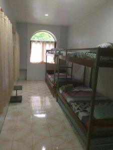 une chambre avec trois lits superposés et une fenêtre dans l'établissement TGH 2 The Garden Villa The Guest House Badian, à Dagatan