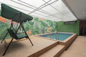 una piscina en una habitación con un mural en RedDoorz Plus near Lembang Park & Zoo, en Bandung