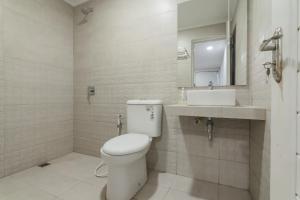 Un baño blanco con inodoro y lavabo. en RedDoorz Plus near Lembang Park & Zoo, en Bandung 17 fotos más