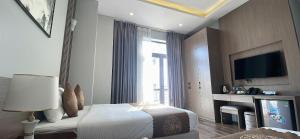 a hotel room with a bed and a television at Hải An Hotel in Hoa Yên