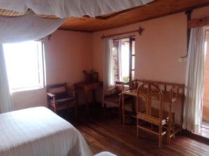 a bedroom with a bed and a table and chairs at Chez Julienne in Fianarantsoa