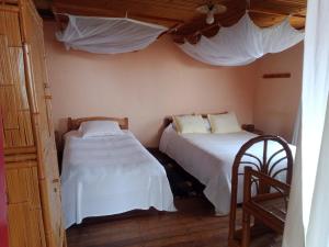 a bedroom with two beds with white sheets at Chez Julienne in Fianarantsoa +28 photos