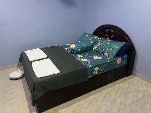 a small bed in a room with a blue wall at H&S RIS Homestay in Kuala Terengganu