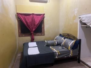 a small bed in a room with a window at H&S RIS Homestay in Kuala Terengganu +3 photos