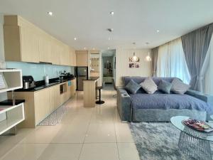 a living room with a couch and a kitchen at Accommodation with waterpark in Pattaya South