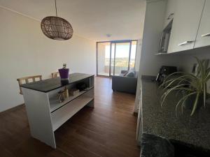 a living room with a table and a couch at Depto equipado - WiFi rápido - 1 min de UCM - piscina rooftop in Talca +2 photos