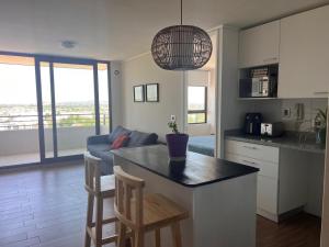 a kitchen and living room with a table and chairs at Depto equipado - WiFi rápido - 1 min de UCM - piscina rooftop in Talca
