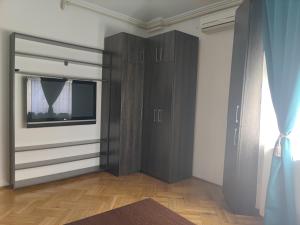 1 dormitorio con armarios negros y ventana en Christie's central apartment, en Bucarest