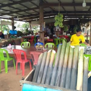 a man standing in front of a table with chairs at Mondulkiri tour and family homestay in Krong Saen Monourom