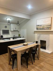 a kitchen and dining room with a table and a fireplace at Eton Cottage - Central Boutique Stay in Toowoomba