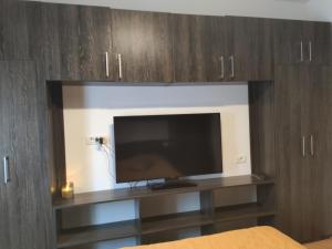 TV de pantalla plana en un centro de entretenimiento en Christie's central apartment, en Bucarest