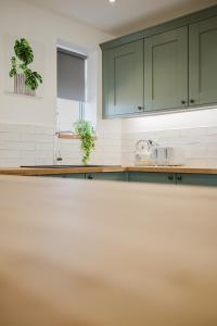 a kitchen with green cabinets and a counter top at Gatekeepers Cottage - Idyllic 4 Bed Rural Escape! in Cropthorne +152 photos