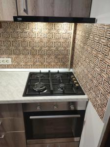 cocina con fogones junto a una encimera en Christie's central apartment, en Bucarest 5 fotos más