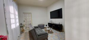 a living room with a couch and a television at Suit Confort in Porto Velho
