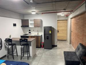 a kitchen with a refrigerator and a table and chairs at Medellín Apartment Loft in Medellín