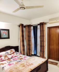 una camera da letto con un letto e una finestra con tende di Simply Apartement Rent a Dhaka