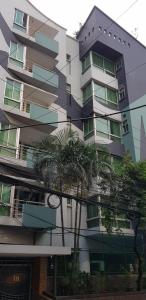 un edificio alto con palme di fronte di Simply Apartement Rent a Dhaka