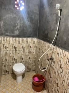 a bathroom with a toilet and a shower at Bunaken Scuba Homestay in Tanjungkarang