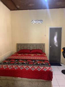 a bedroom with a large bed with red pillows at Bunaken Scuba Homestay in Tanjungkarang