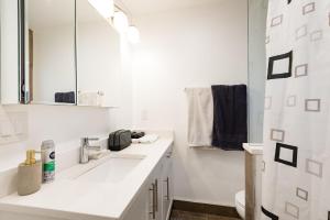 a white bathroom with a sink and a mirror at Beautiful Vancouver Cedar Cottage House in Vancouver +10 photos