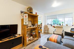 a living room with a couch and a television at Beautiful Vancouver Cedar Cottage House in Vancouver