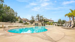 a swimming pool in a yard with chairs and trees at Sweet Serenity 3 bed with community pool, spa in Encinitas