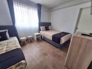 una camera d'albergo con due letti e una finestra di Hotel MAXIMUM COMFORT FCA a Salinas