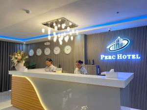 two women sitting at a reception counter in a hotel at Perc Hotel in Pinamungahan
