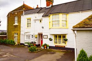 une maison blanche avec une porte rouge dans l'établissement The Beaumont, à Sittingbourne