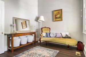 a living room with a couch and a mirror at Cosy on Mair in Ballarat