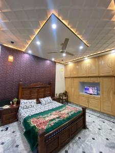 a bedroom with a large bed and a tv at Gulistan Inn in Faisalabad