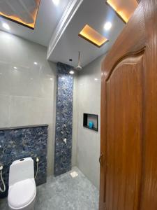 a bathroom with a toilet and a wooden door at Gulistan Inn in Faisalabad +32 photos