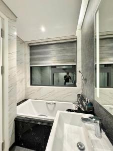 a bathroom with a tub and a sink and a mirror at Altara Residences Apartment - Căn Góc View Biển in Quy Nhon