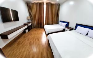 a hotel room with two beds and a television at Cat Ba Charm Island Hotel in Cat Ba +48 photos