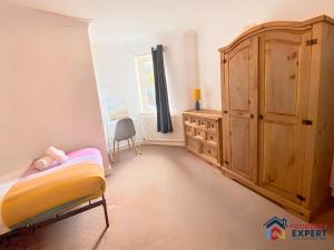 een slaapkamer met een bed en een houten kast bij BridgeView Central Cambridge with Parking Off Site F6 in Cambridge