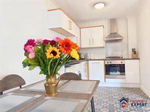 een vaas met bloemen op een tafel in een keuken bij BridgeView Central Cambridge with Parking Off Site F6 in Cambridge