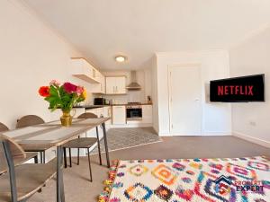 een woonkamer met een tafel en een keuken bij BridgeView Central Cambridge with Parking Off Site F6 in Cambridge