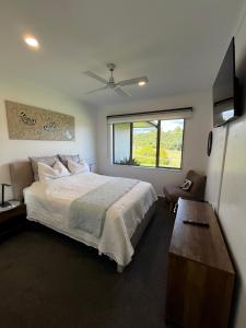 a bedroom with a large bed and a window at McLaren Lake View in Tauranga