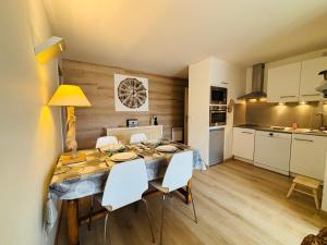 オトゥランにあるAppartement rénové à Autrans, idéal pour nature et randonnées - FR-1-737-97のテーブルと椅子のあるキッチンとダイニングルーム