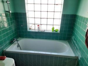 a green tiled bathroom with a tub and a window at Maison familiale rénovée pour 13 pers. à Royan, proche plage - FR-1-494-204 in Royan