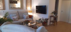 a living room with a couch and a tv at Apto a estrenar 1 golf para 4p Islantilla in Isla Cristina