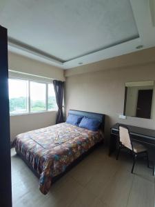 une chambre avec un lit, un bureau et une fenêtre dans l'établissement Lovers Island homestay, à Batu Ferringhi
