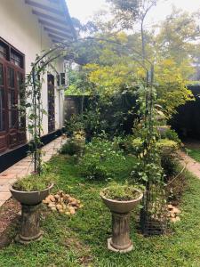 a garden with two stone vases in the grass at Villa De Wick's in Kimbulapitiya