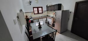 a kitchen with a table and a refrigerator at Villa De Wick's in Kimbulapitiya