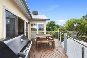 Un balcón con bañera y una mesa en una terraza. en Casablanca Beach House, en Torquay
