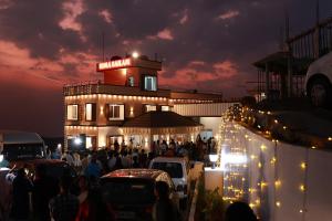 Himasailam Pool Resort Vagamon في فاغامون: زحمة الناس امام مبنى فيه انوار