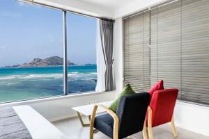 a living room with a view of the ocean at Here Now pension in Jeju