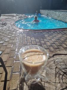 una persona en una piscina con una bebida en Boschendal Guesthouse, en Kimberley