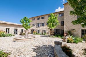 a courtyard with a fountain in front of a building at La Bastide de Clara in Oppède